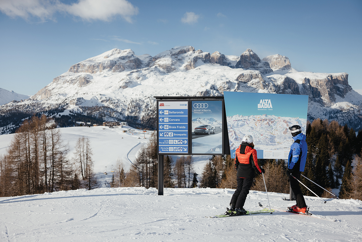 Skiers in front of directional signage in Alta Badia